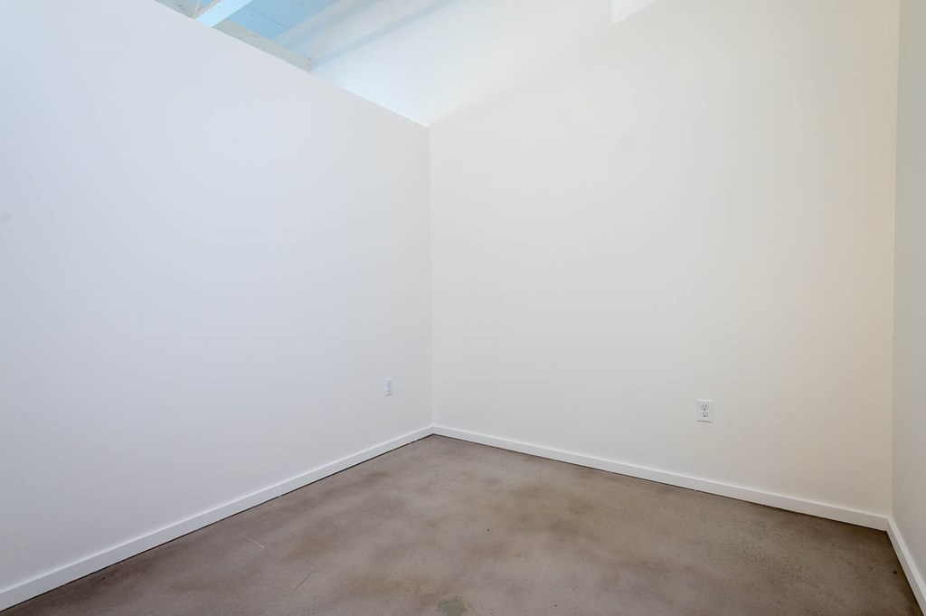 a empty room with white walls and a concrete floor