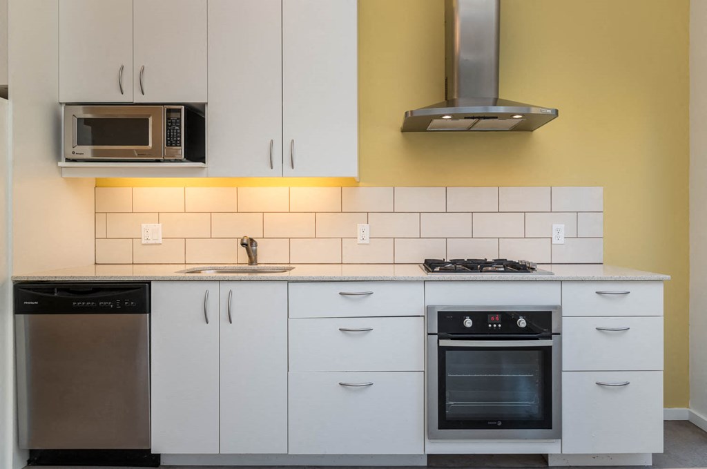 a kitchen with white cabinets and a stove and a microwave