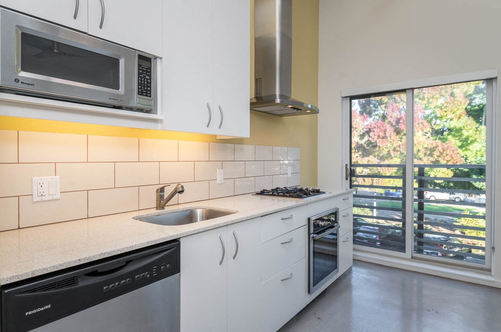 a kitchen with a sink and a microwave and a window