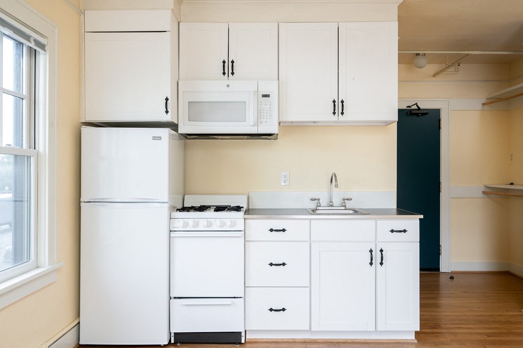 a kitchen with white appliances and white cabinets