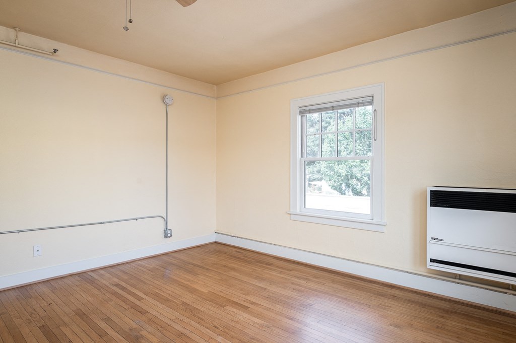 an empty room with a radiator and a window