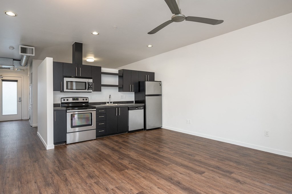 a kitchen with black and white appliances and a ceiling fan