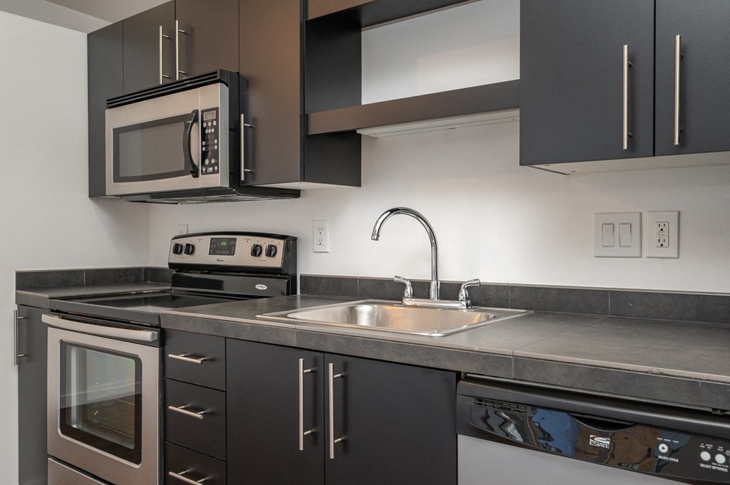 an empty kitchen with a sink and stove and a microwave