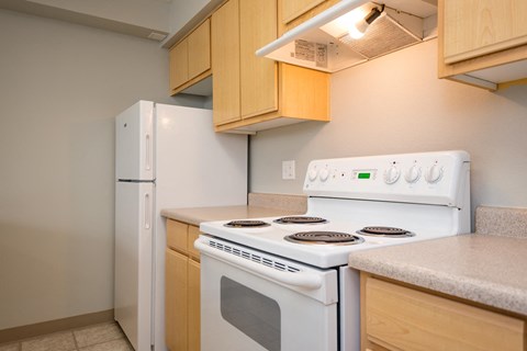 a kitchen with a white stove and a refrigerator