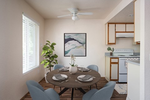A dining room with a table set for two and a painting on the wall.