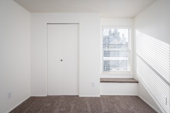 a small window in a room with a carpeted floor and a white door with a window - Photo Gallery 23