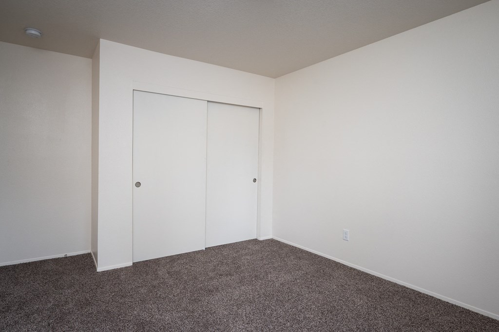 an empty room with carpet and white walls