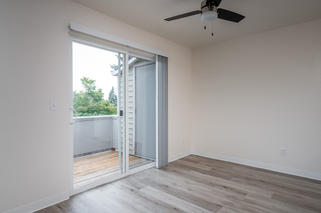 an empty room with a sliding glass door to a balcony