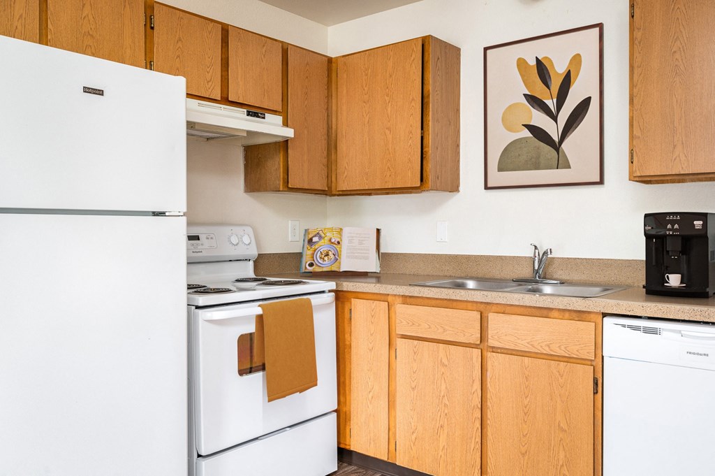 a kitchen with white appliances and wooden cabinets