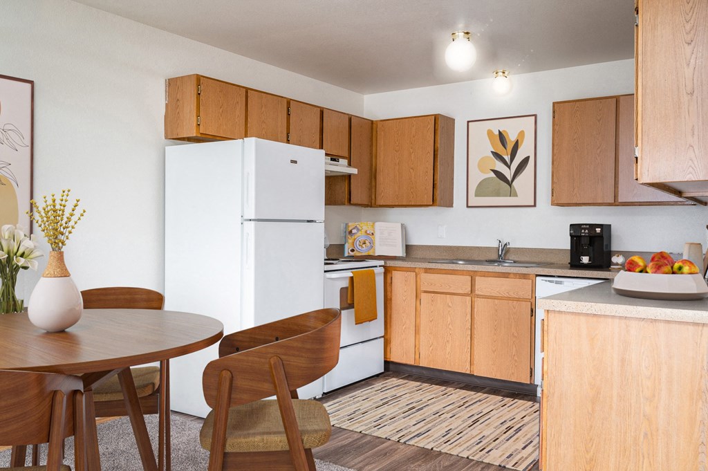 a kitchen and dining area with a table and chairs and a refrigerator