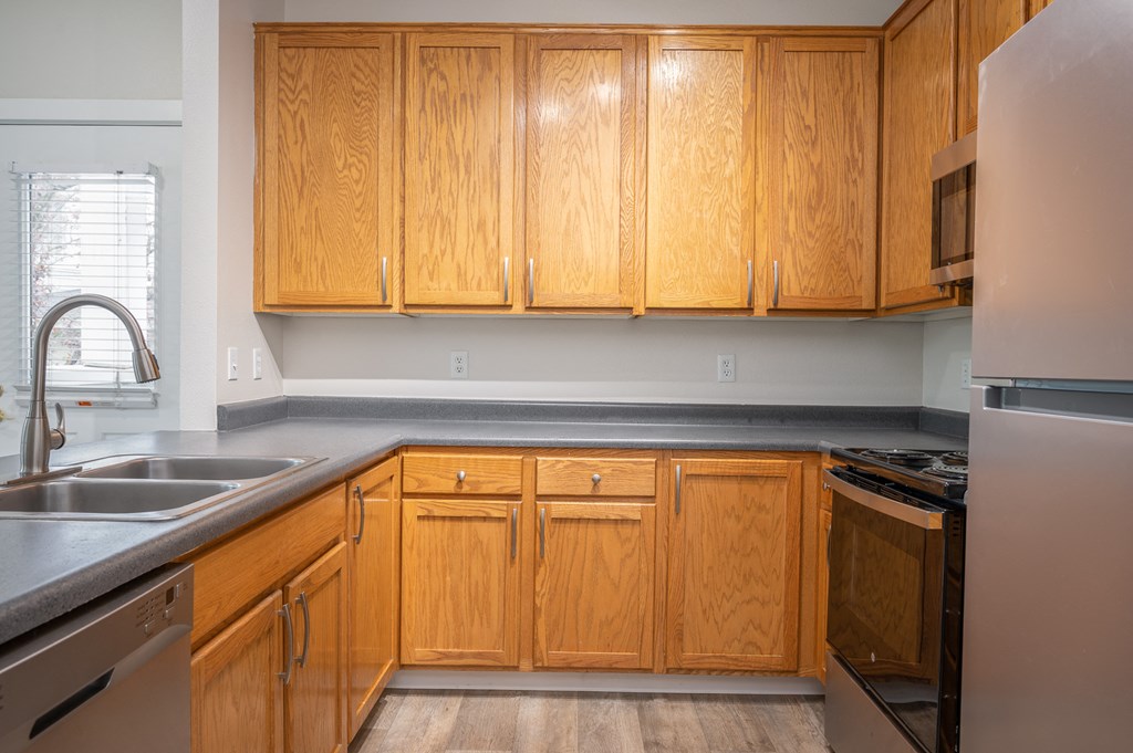 a kitchen with wooden cabinets and stainless steel appliances