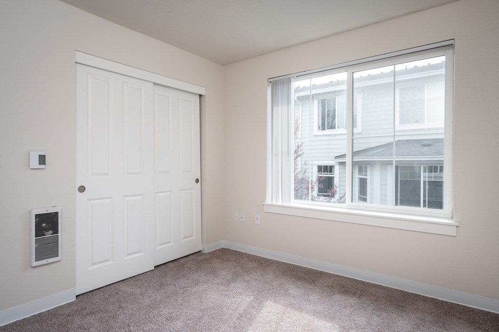 a bedroom with a large window and a white door