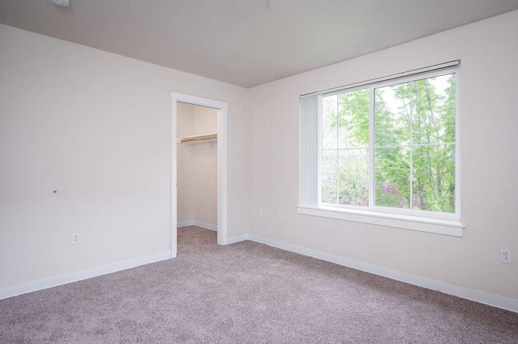 a bedroom with a large window and carpet