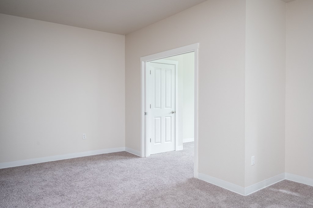 a bedroom with white walls and carpet