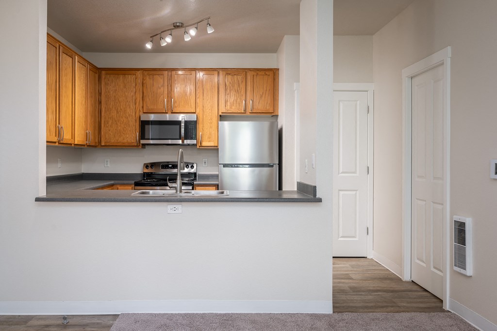 a kitchen with wood cabinets and stainless steel appliances