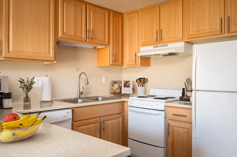 A kitchen with wooden cabinets and a white refrigerator.