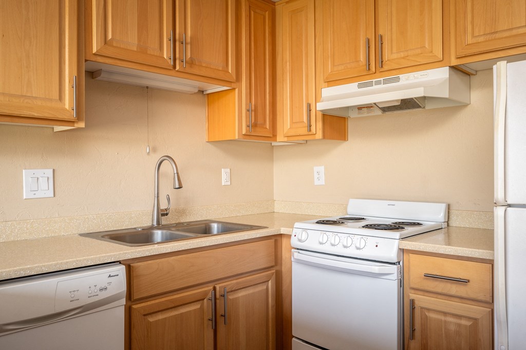 a kitchen with white appliances and wooden cabinets