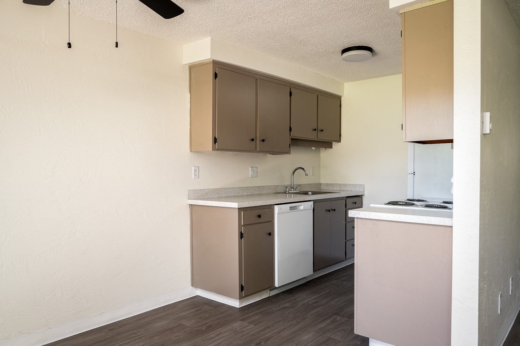 an empty kitchen with a counter top and a sink