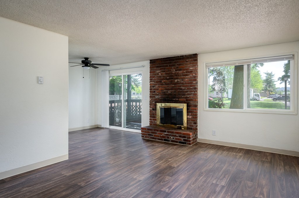 an empty living room with a fireplace and a sliding glass door