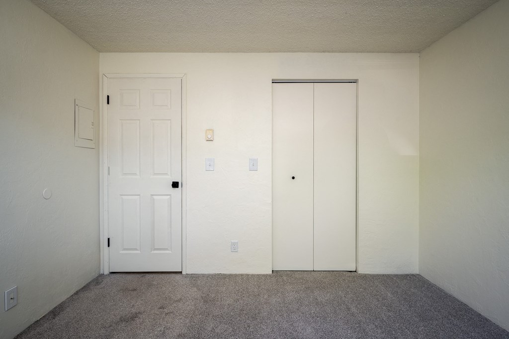 an empty room with a door and a closet