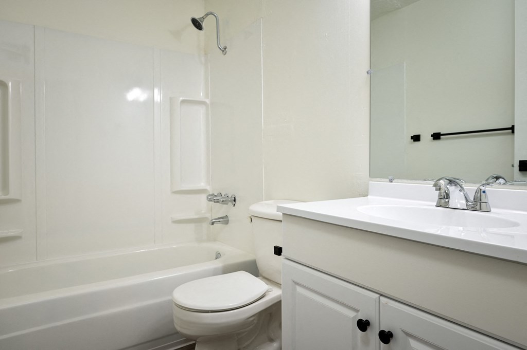 a white bathroom with a sink toilet and bath tub