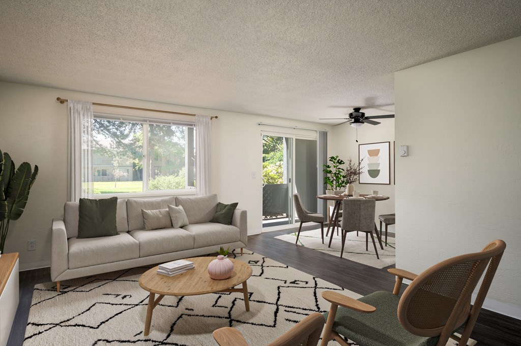 A living room with a couch, a chair, a table, and a ceiling fan.