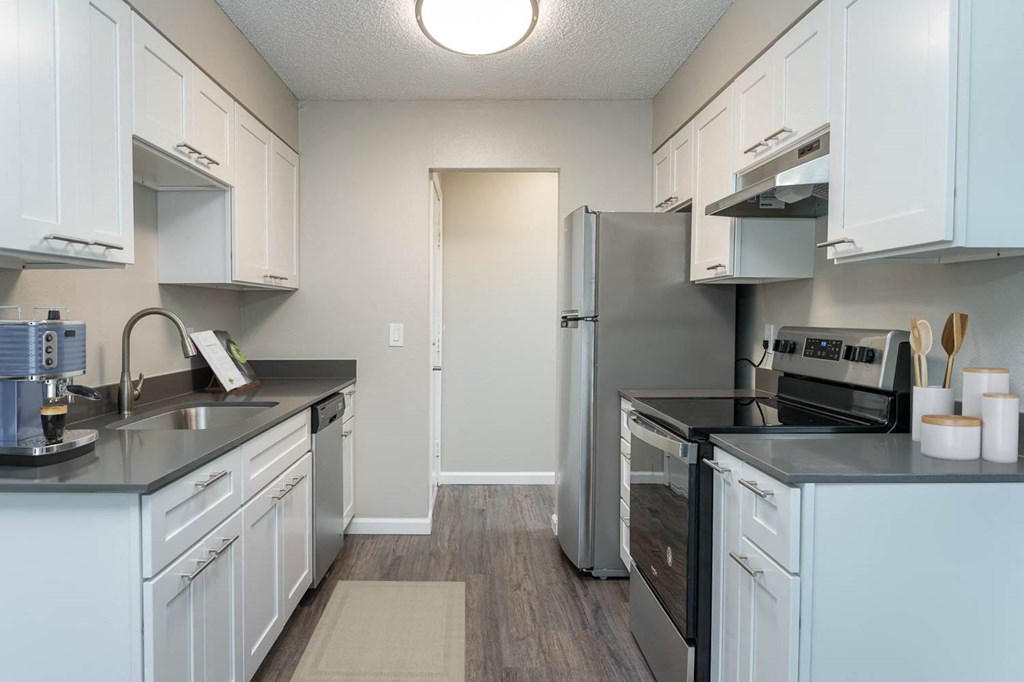 a kitchen with white cabinets and a stainless steel refrigerator