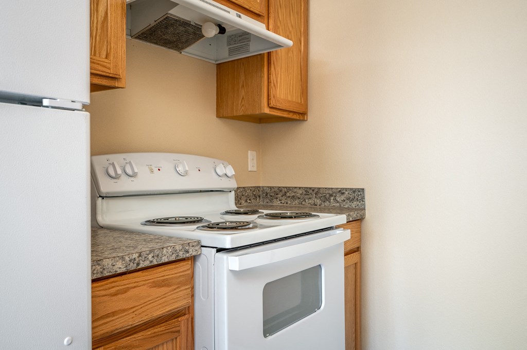 a kitchen with a white stove and a refrigerator