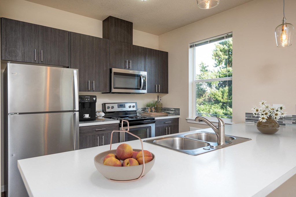 a kitchen with stainless steel appliances and a bowl of fruit