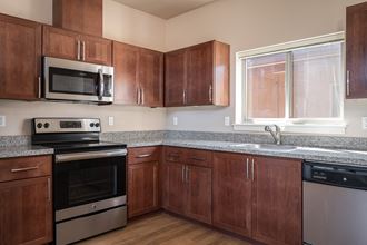 a kitchen with wooden cabinets and granite countertops