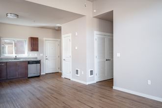 a kitchen and living room with hardwood floors and white walls