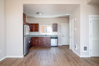 a kitchen with wood flooring and stainless steel appliances