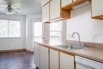 a kitchen with white cabinets and a white dishwasher