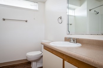 a bathroom with a toilet sink and mirror - Photo Gallery 7