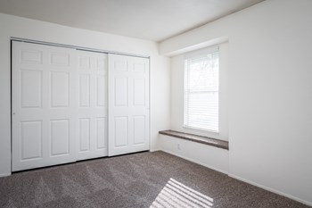 a bedroom with two closets and a window - Photo Gallery 6