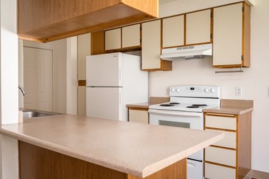 a kitchen with white appliances and wooden cabinets