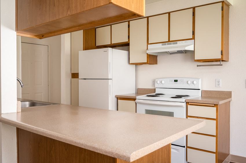 a kitchen with white appliances and wooden cabinets - Photo Gallery 1