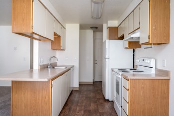 a kitchen with white appliances and wooden cabinets