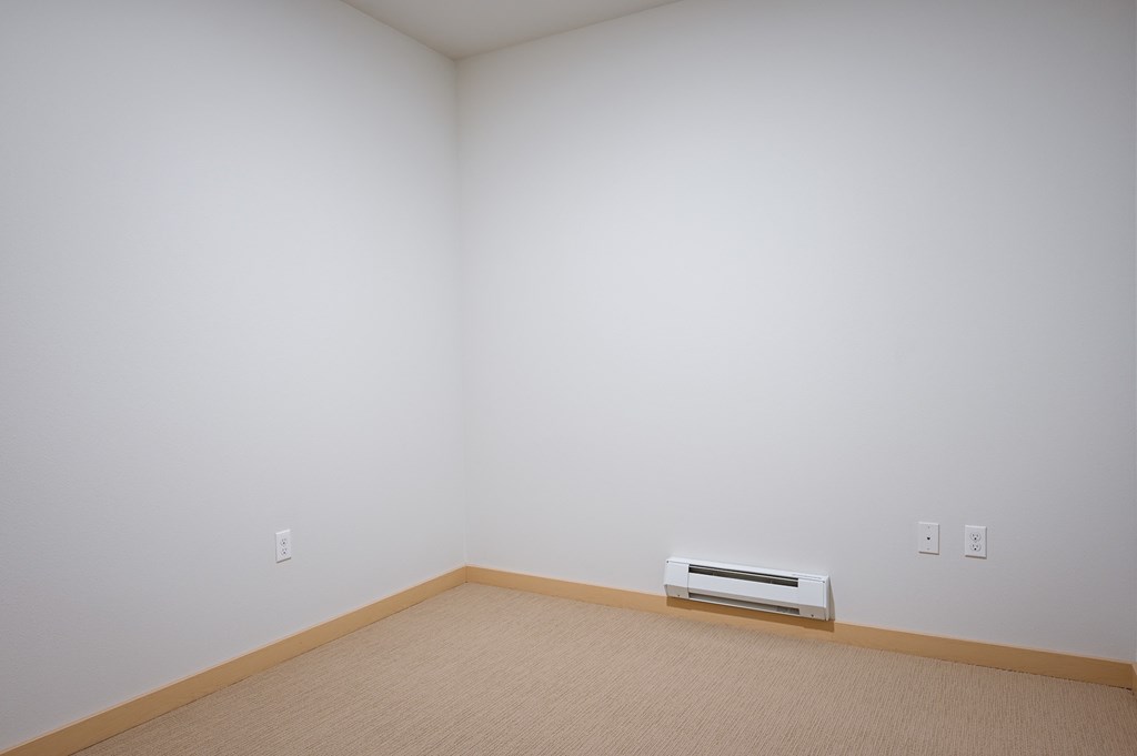bedroom with a heater and carpet
