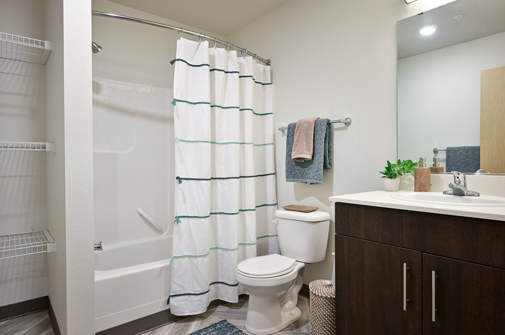 bathroom with a shower, sink and a toilet