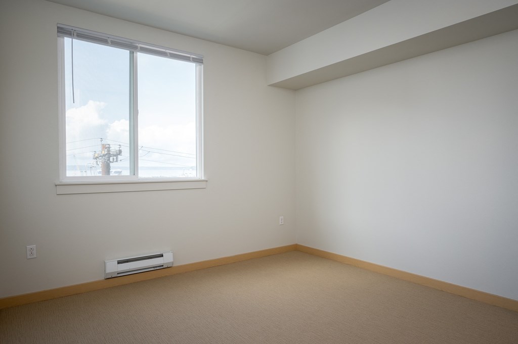 bedroom with a large window and carpet