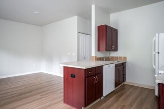 a kitchen with white countertops and dark wood cabinets - Photo Gallery