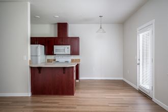 a kitchen with white appliances and a wooden floor - Photo Gallery