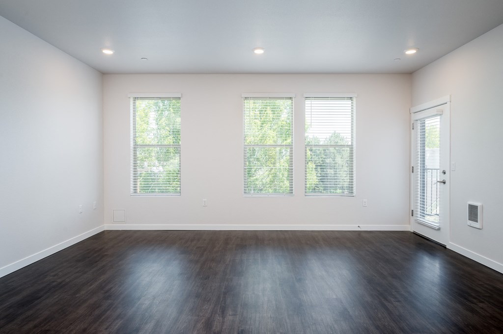 a bedroom with hardwood floors and white walls