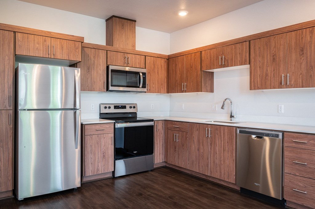 a kitchen with wooden cabinets and stainless steel appliances