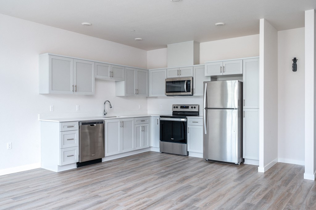 a kitchen with white cabinets and stainless steel appliances