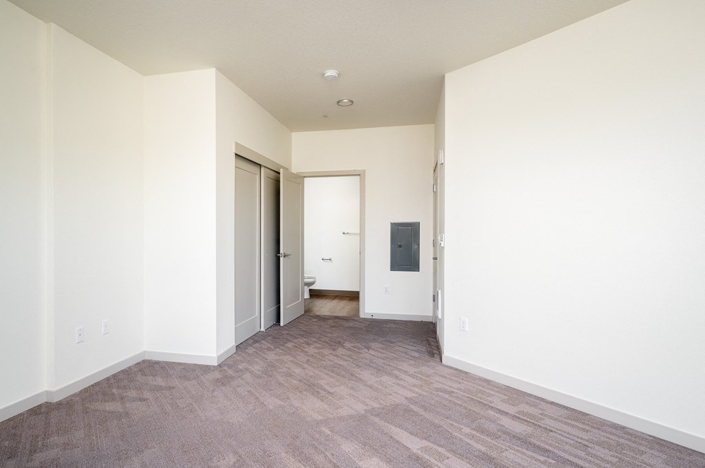 an empty living room with white walls and a wood floor