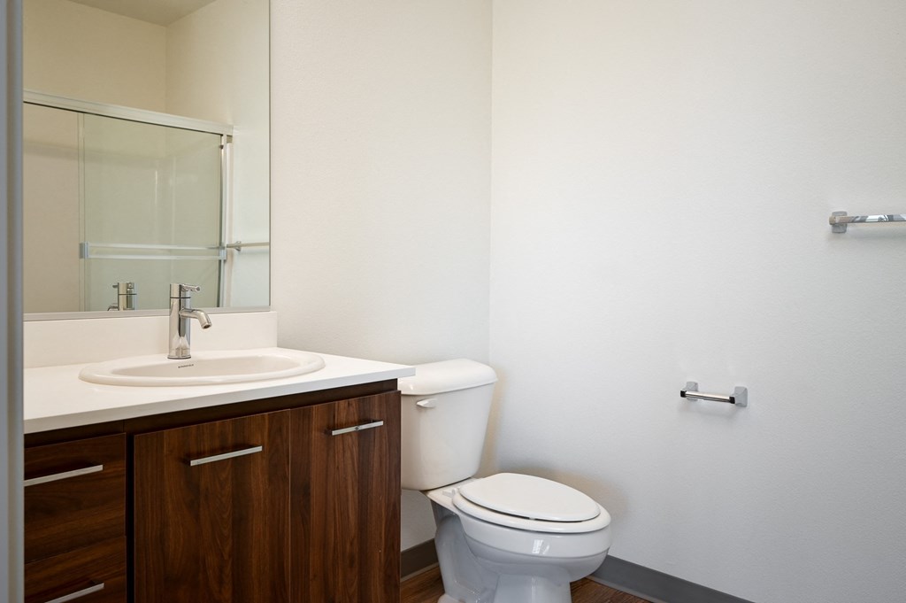 an empty bathroom with a toilet sink and mirror