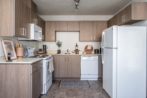 a kitchen with white appliances and wooden cabinets