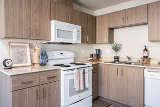 a kitchen with white appliances and wooden cabinets